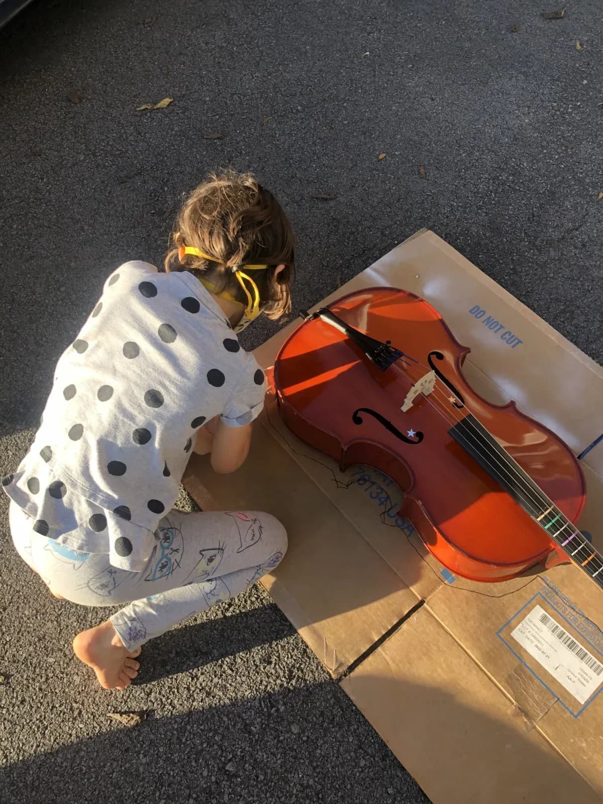 A young Knoxville Suzuki Academy cellist with her instrument