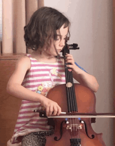 Image showing a child twisting to stare at her fingers to find the notes. Note how this causes the left elbow to drop and the spine to twist.