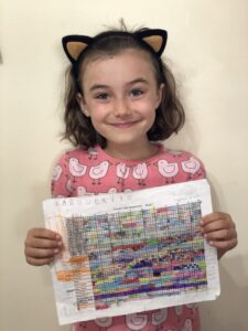 Child holding a completed 100s Suzuki book 1 chart.